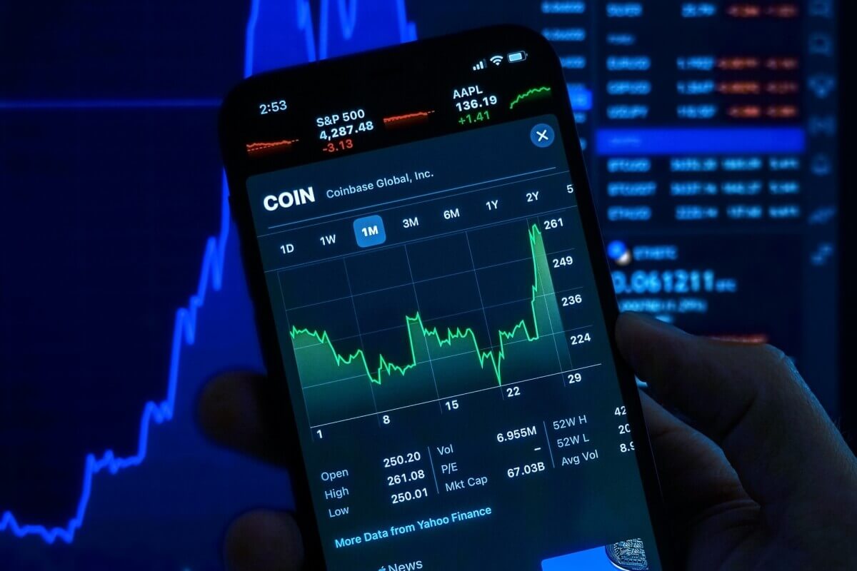 Stock chart on a smartphone with market data in the background